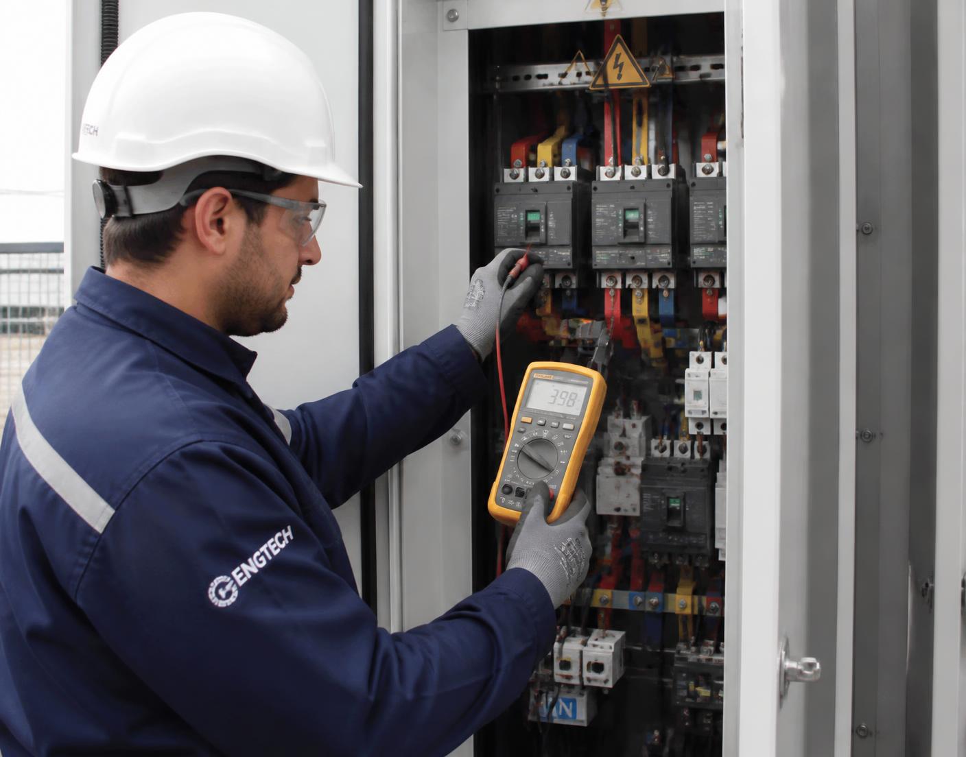 Inspecteur meet elektrische componenten in een schakelkast